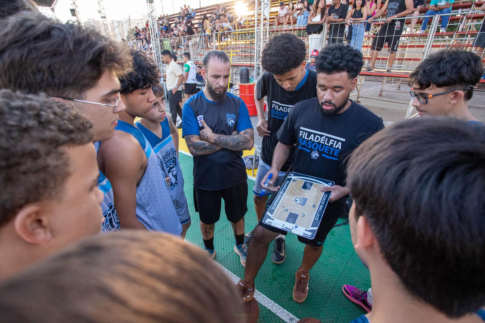 Coach Wallace orienta os atletas com a prancheta tática durante o jogo